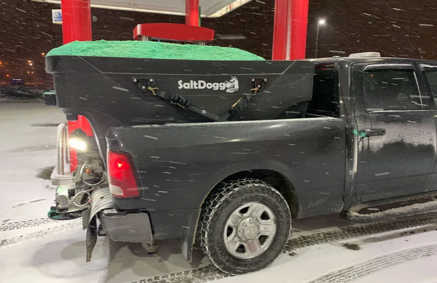 City Mowing salt-spreader truck in snowy conditions for winter de-icing service